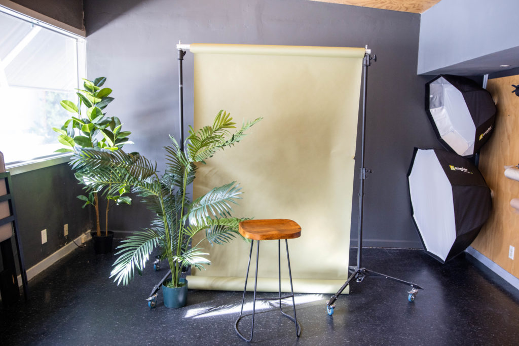 PhotoVibe Studio professional photography workspace with camera equipment, backdrop and studio lights